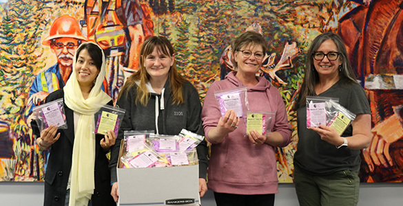 Members of SGEU's Women's Committee hold individually packaged bags of period products.