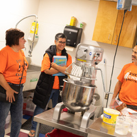 Tracey Sauer and Hali Topinka chat with Pre-Cam Community school principal Ryan Kuppenbender in the school kitchen 